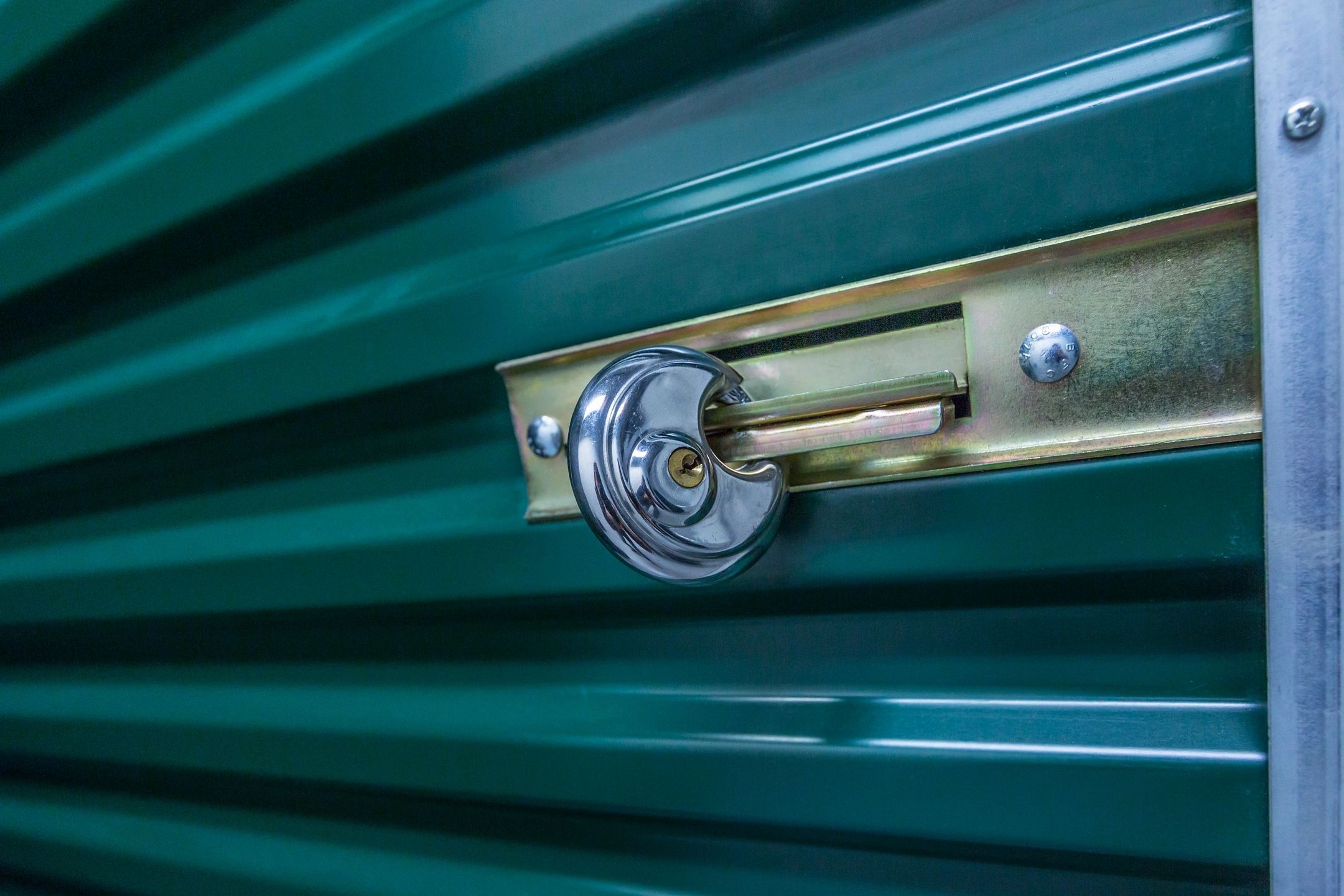 A close up of the key on a green door.